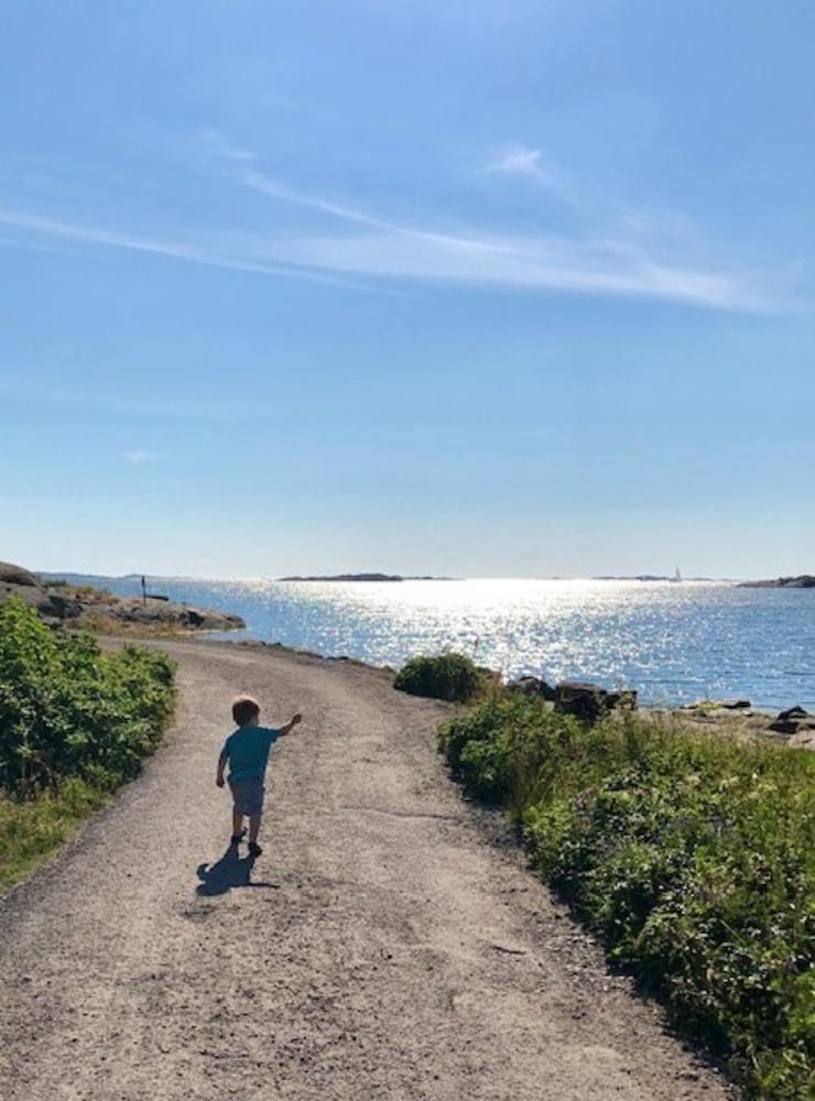 Pojke som pekar på en segelbåt ute på havet.Bilden tagen i Sundhammar den 3 juli av Anneli Sjögren.