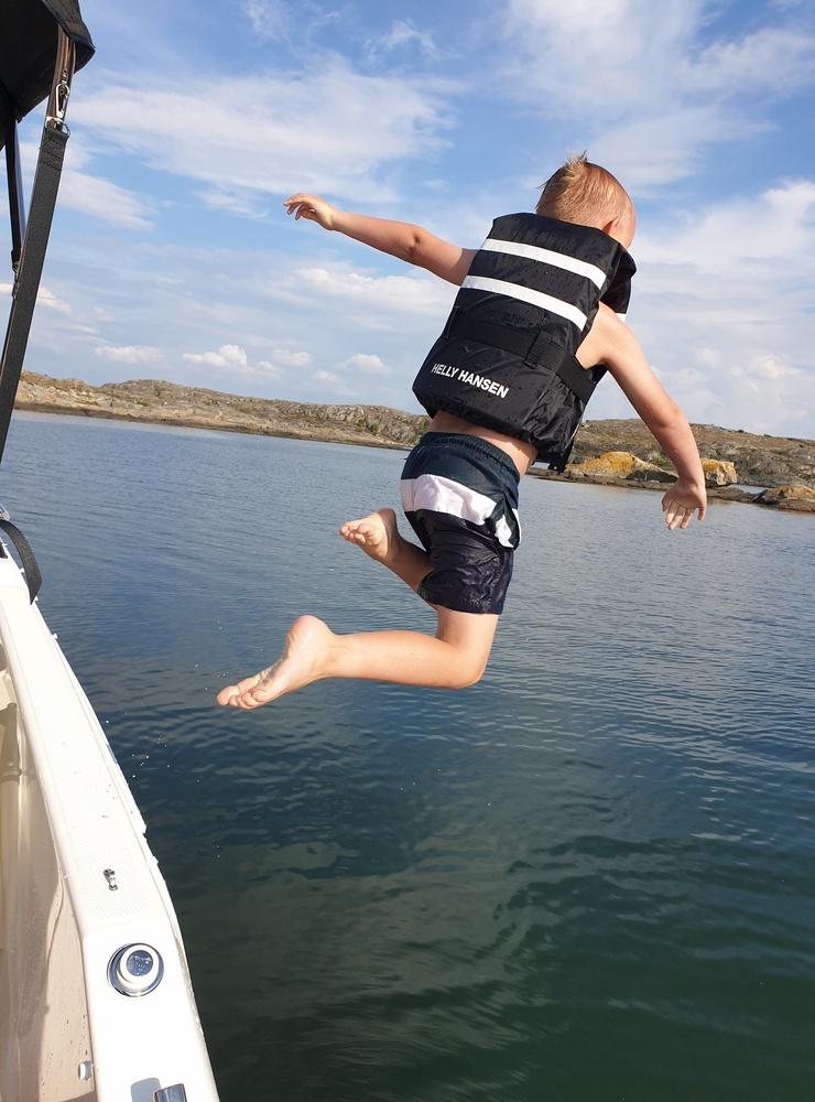 Samuel hoppar från båten strax utanför ön Trälen. Bild: :Lars-Gunnar Rutgersson