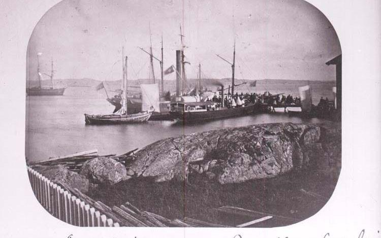 Trängsel vid kajen i södra hamnen i Lysekil. Fotografiet är svårdaterat. Den angivna fotografen, Hugo Hallgren (1870-1933), kan ha fotograferat av ett äldre foto. I bildens mitt skymtar en hjulångare. Även en ångslup av äldre modell är synlig. Originalfotografiet skulle kunna vara taget på 1860-talet. 